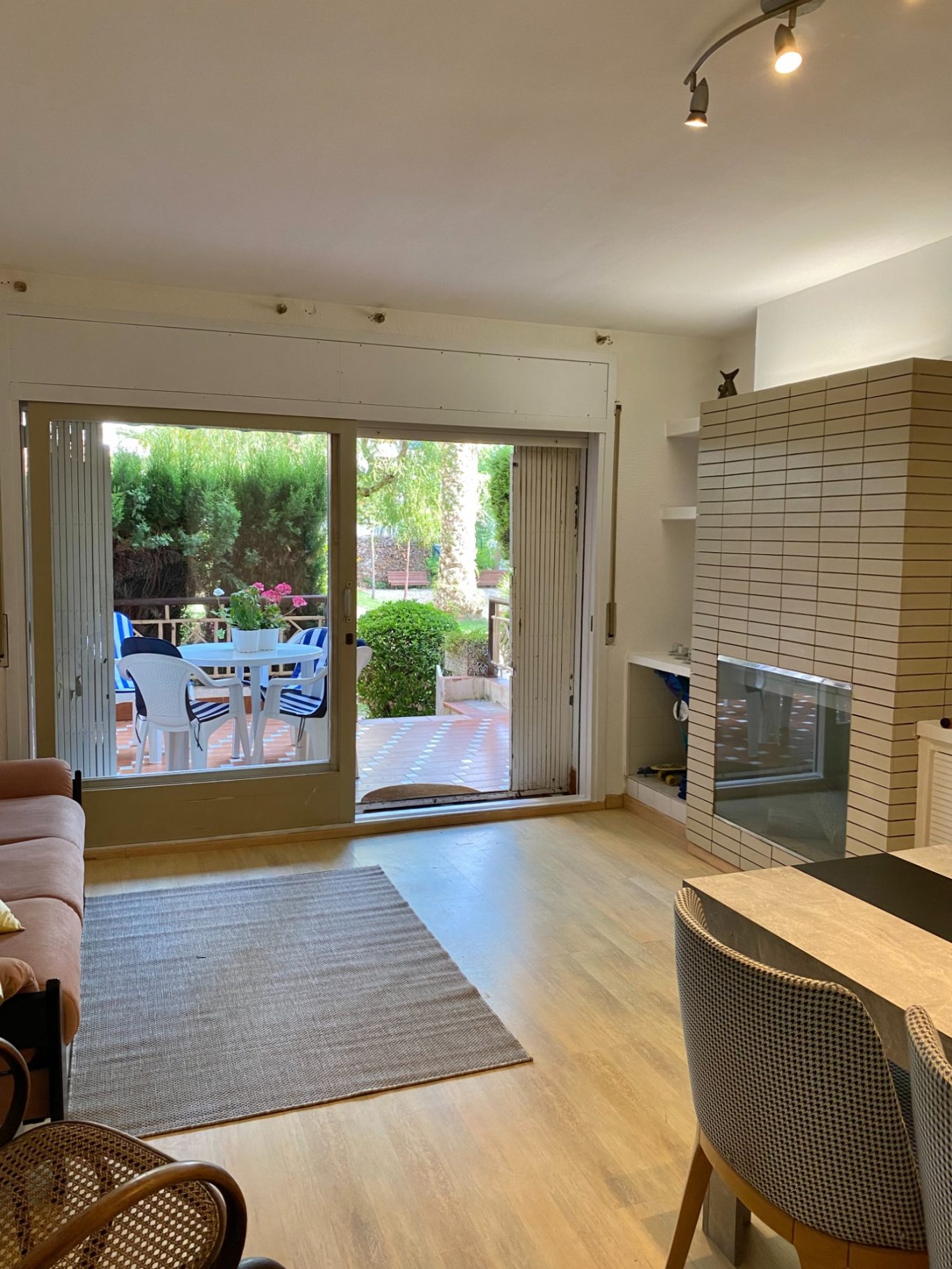 Sala de estar luminosa con acceso a un jardín y muebles modernos.